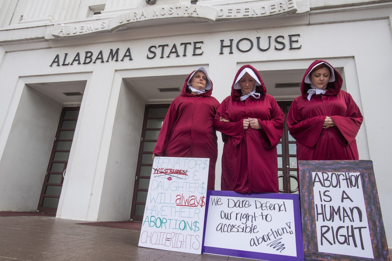 Women dressed as handmaids protested against the abortion ban bill at the Alabama State House.