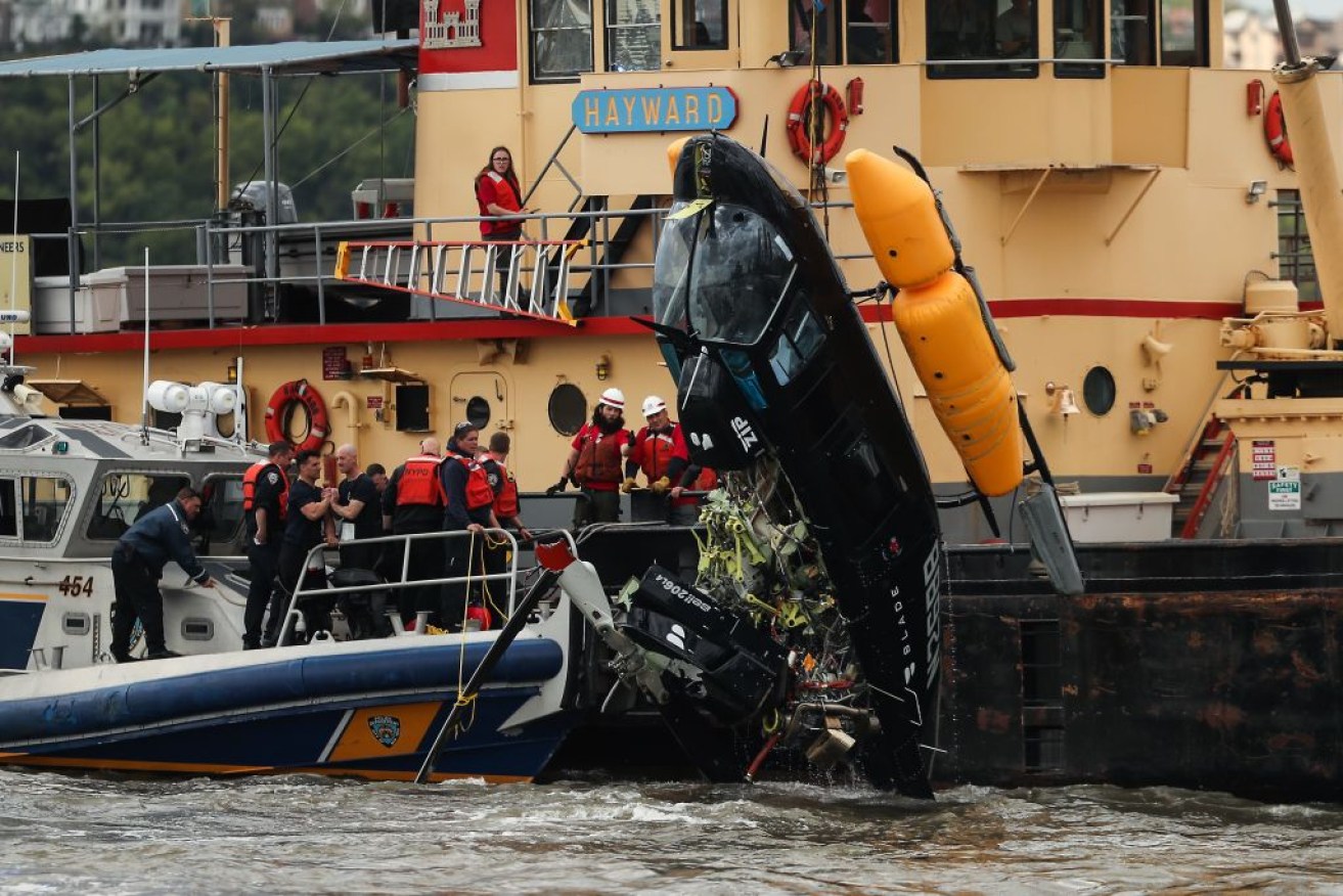 A helicopter is pulled out of the Hudson River after it crashed in New York.