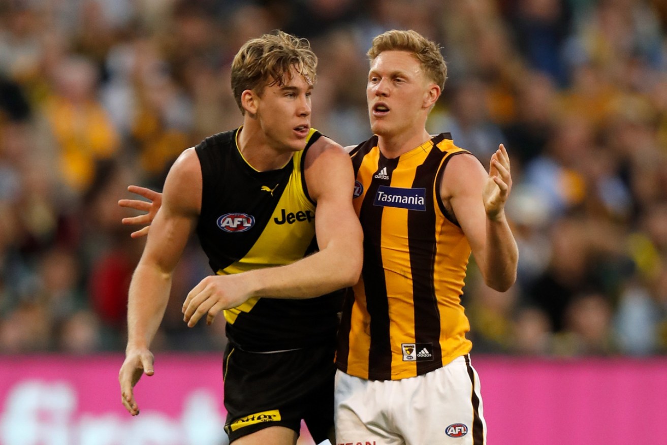 Tom Lynch, of the Tigers, and James Sicily, of the Hawks, tangle at the MCG.