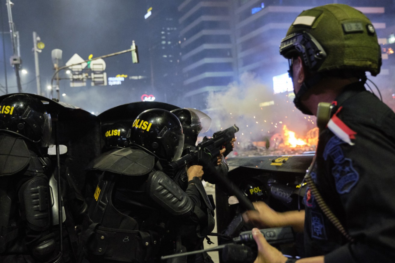 Riot police fire tear gas at demonstrators on the streets of Jakarta.