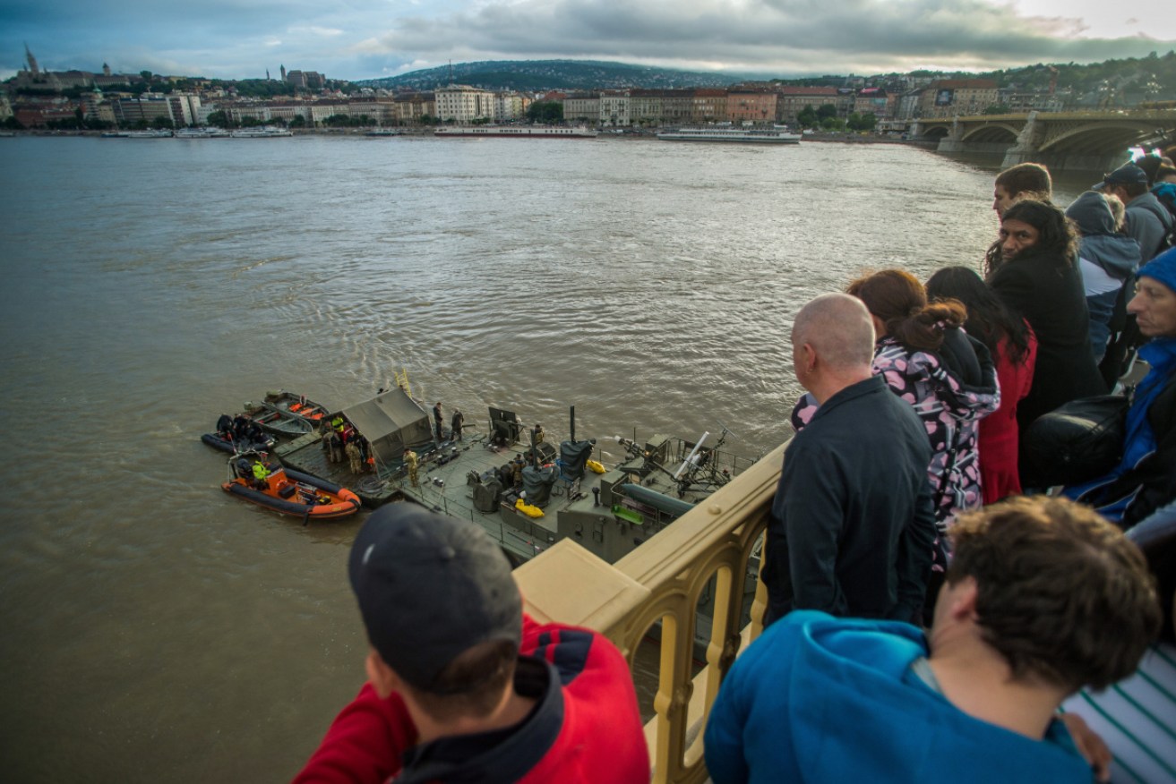 Crowds watch as rescuers prepare to recover the capsized Mermaid.