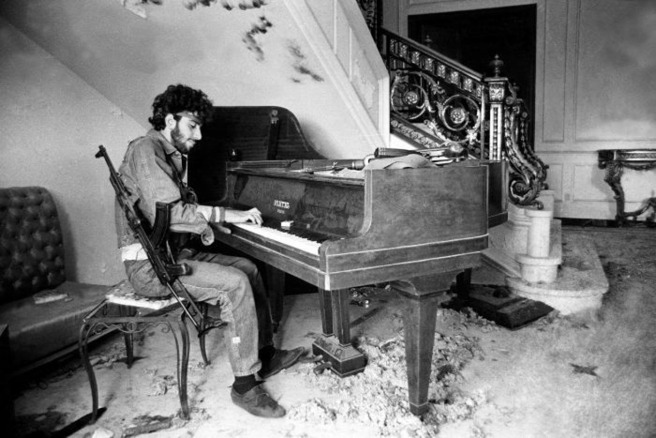 In 1983, photographer Ramzi Haidar took this photo of a militiaman playing the piano in an abandoned mansion.