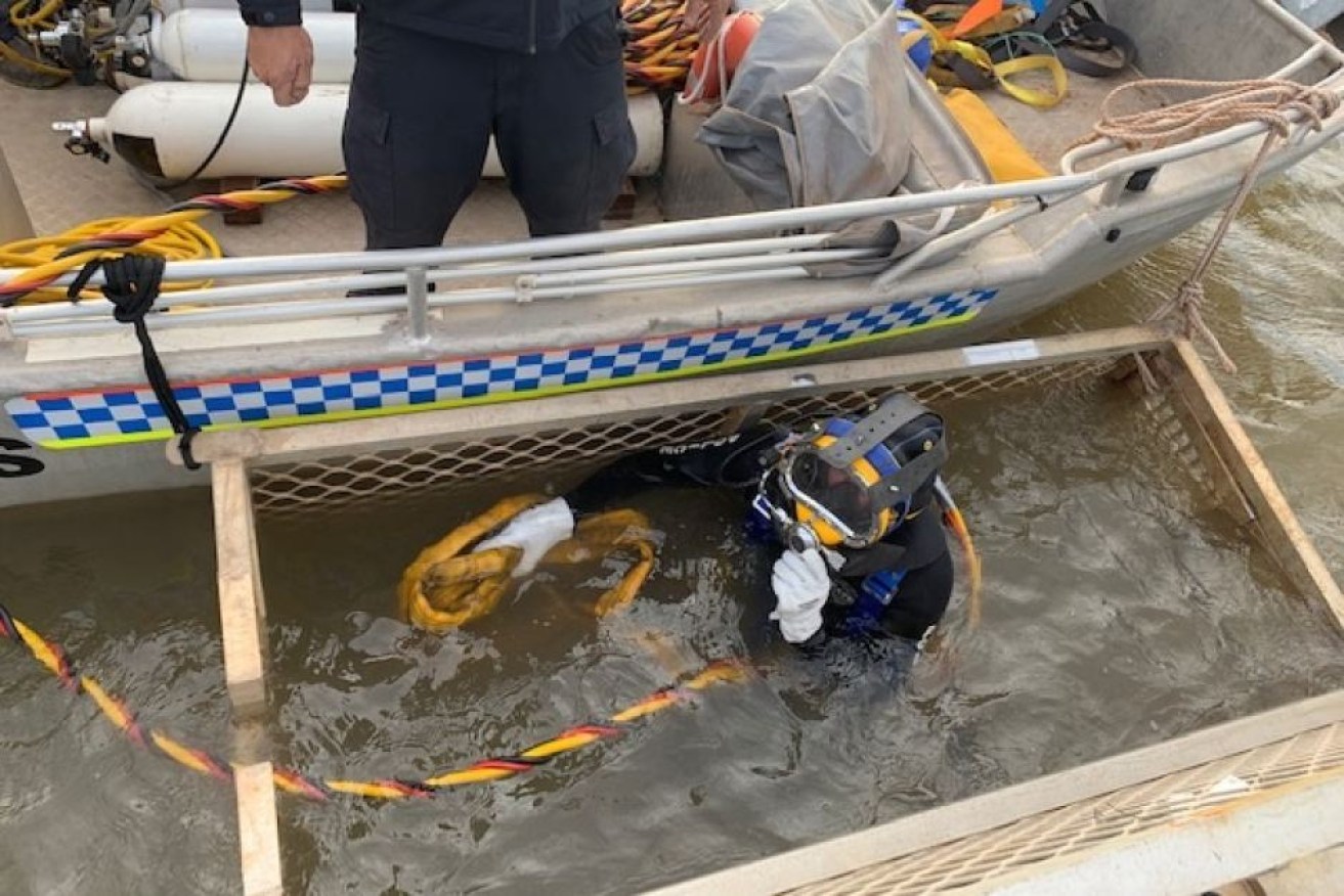 Police used a cage to search the Victoria River for the missing pilot.