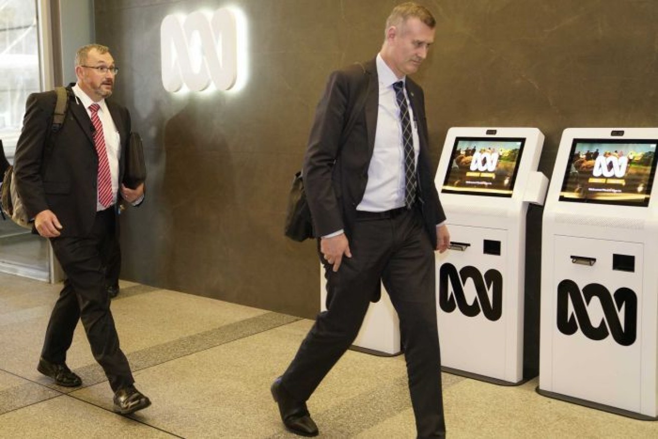 Federal Police officers enter the ABC's Ultimo headquarters on Wednesday.