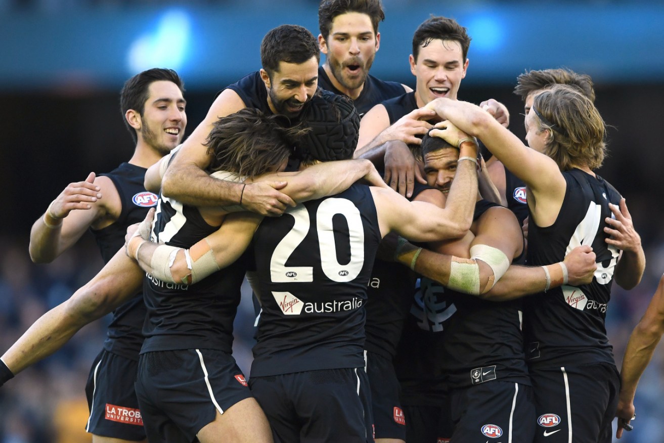 The joy: Carlton players celebrate their win against the Brisbane Lions. 