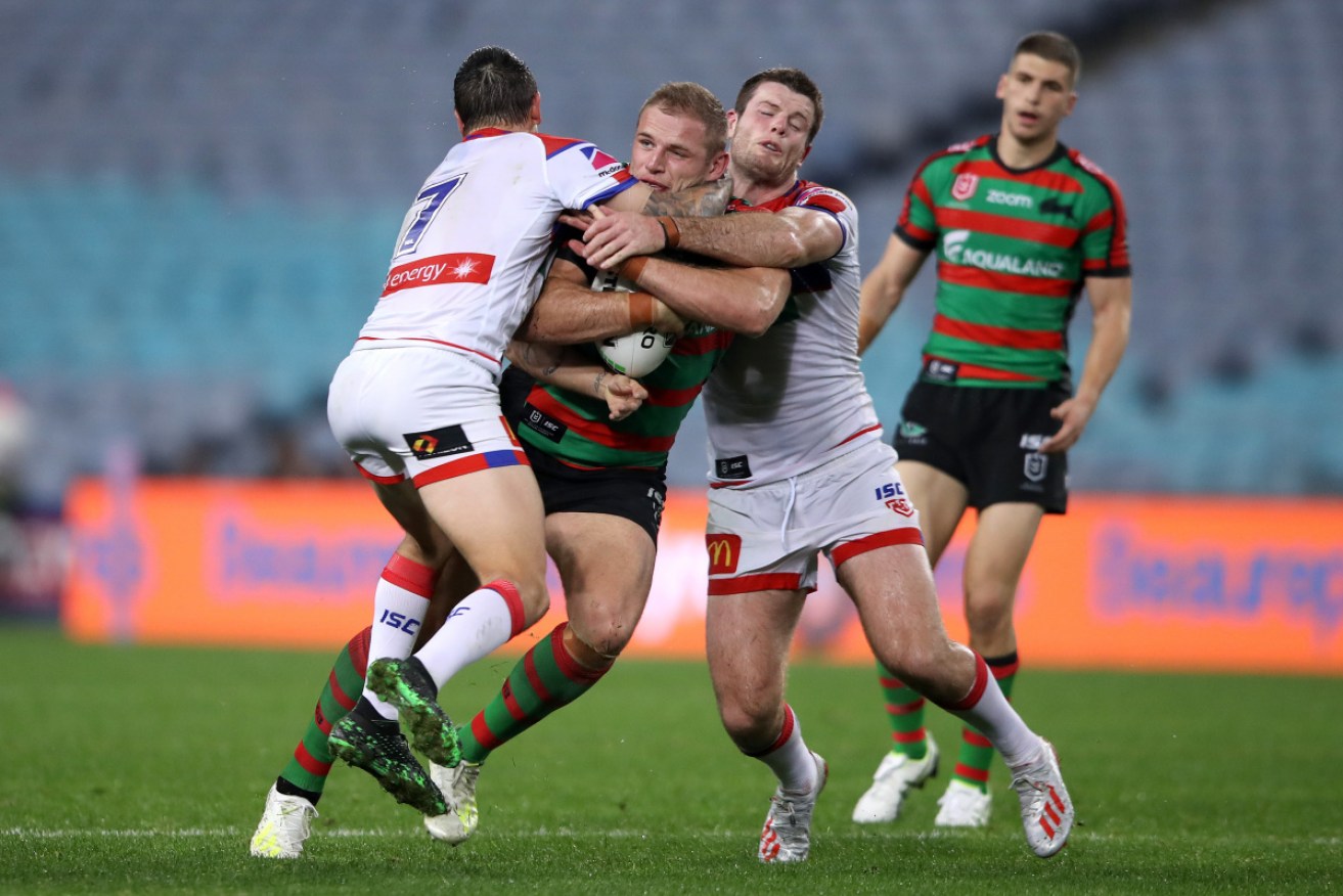 Rabbitoh Tom Burgess is tackled during the fiery match.