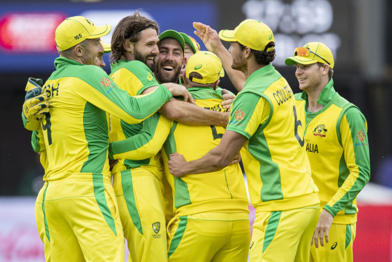 Teammates mob Glenn Maxwell (centre) after his run out to complete victory.