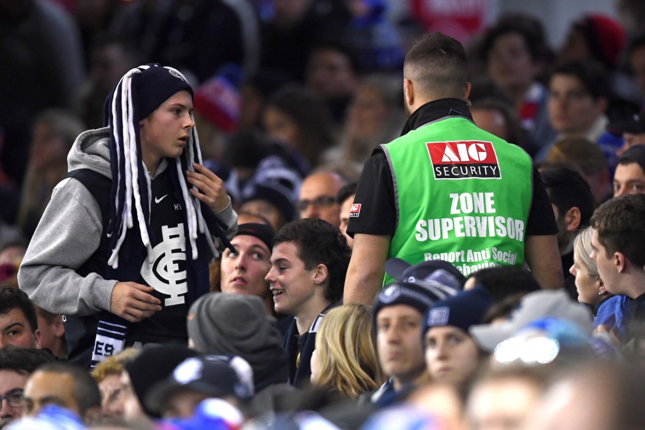 A Marvel Stadium security officer speaks to a fan on Saturday night. 