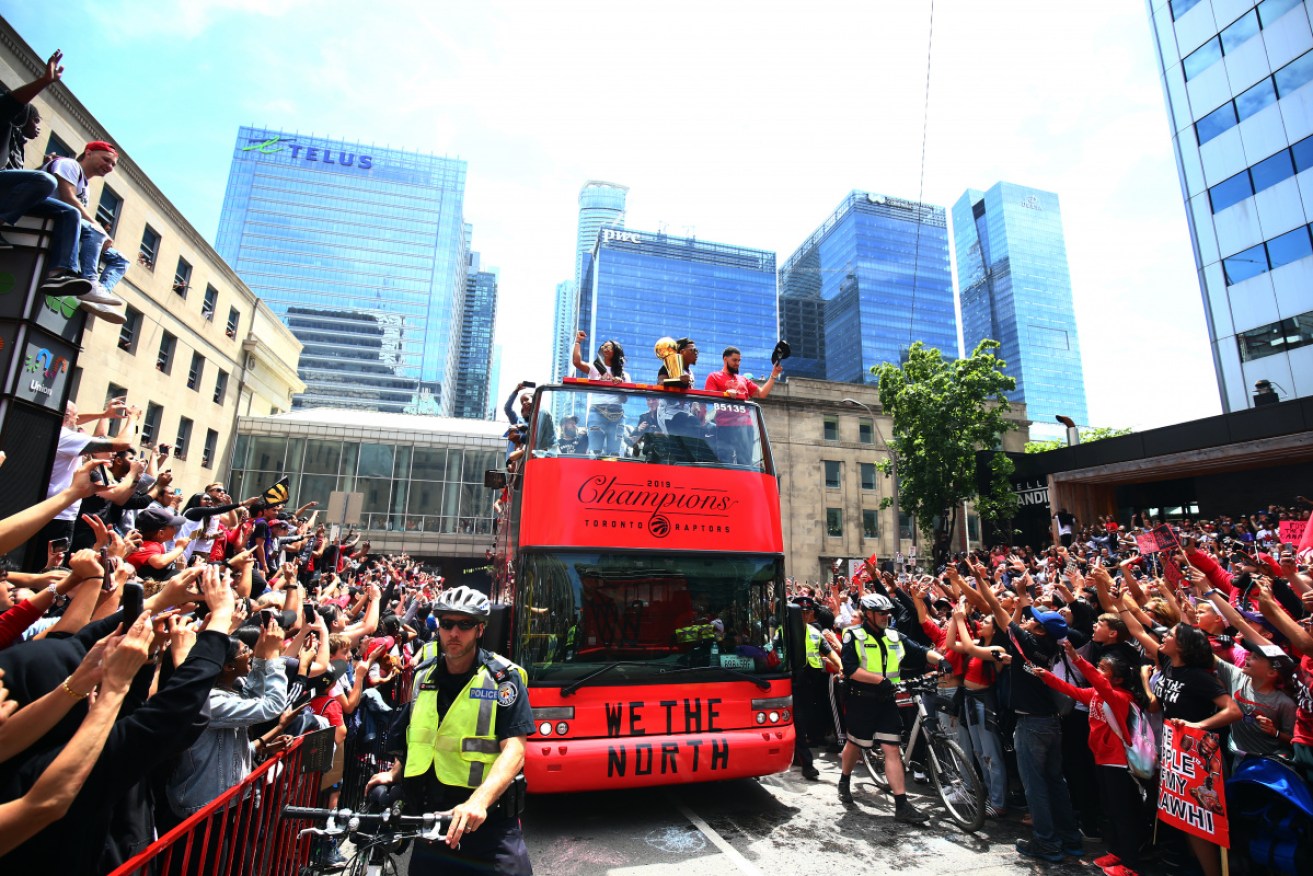 Raptors players edge through the crowd at their victory parade.