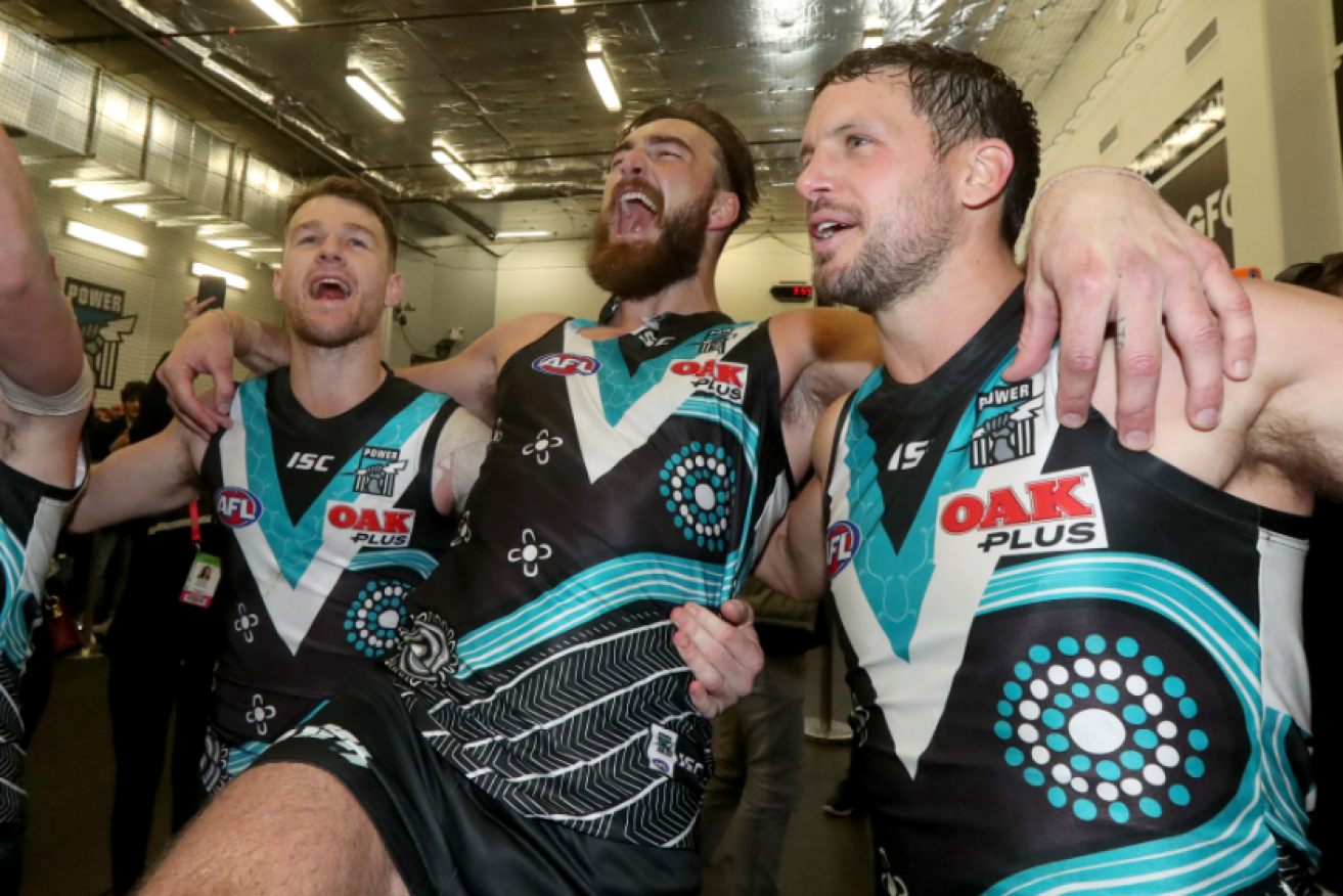 Robbie Gray, Charlie Dixon and Travis Boak of the Power sing the club song after handing Geelong only its second loss for the season.