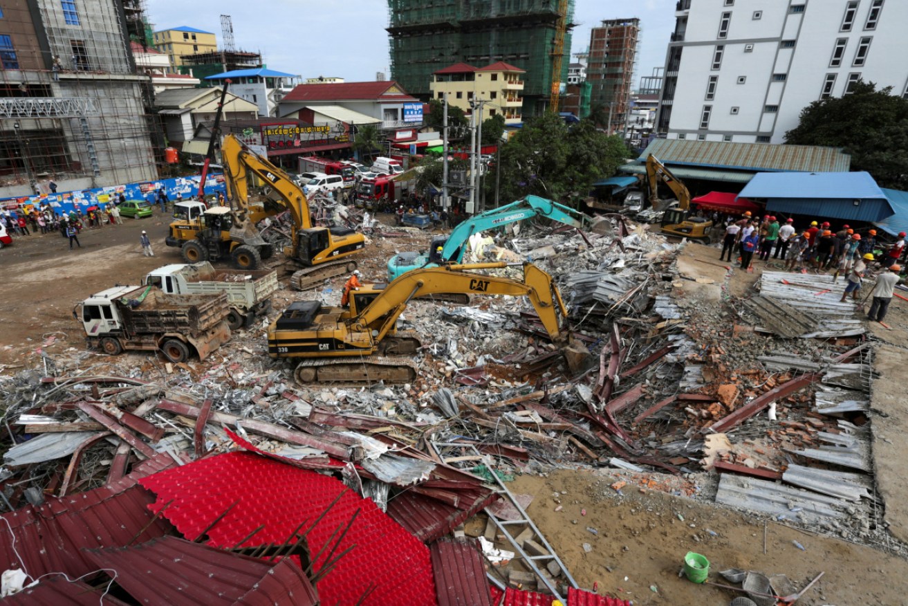 Rescue workers clear debris as they search for victims a day after an under-construction building collapsed in Sihanoukville.