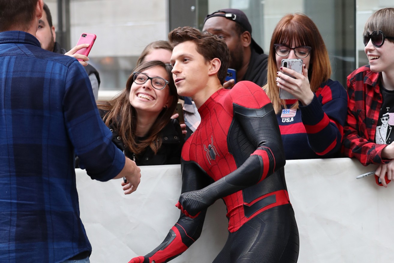 Dressed in costume, <i>Spider-man: Far From Home</i> star Tom Holland greets fans outside his London hotel on June 21.
