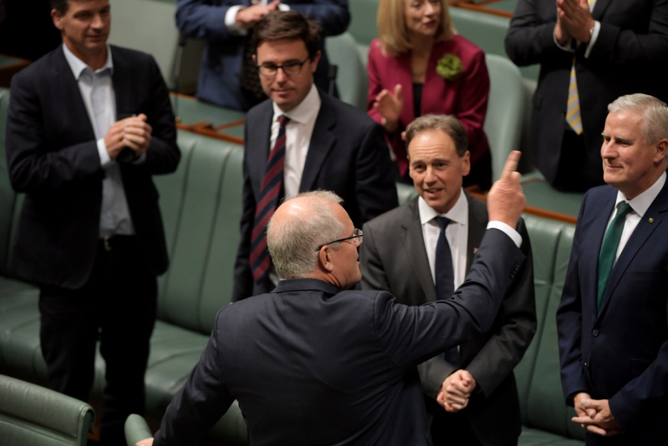 Prime Minister Scott Morrison salutes after the tax cuts were passed on Thursday night. 