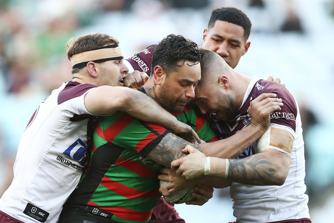 John Sutton of the Rabbitohs Is tackled by the Sea Eagles' defence.  