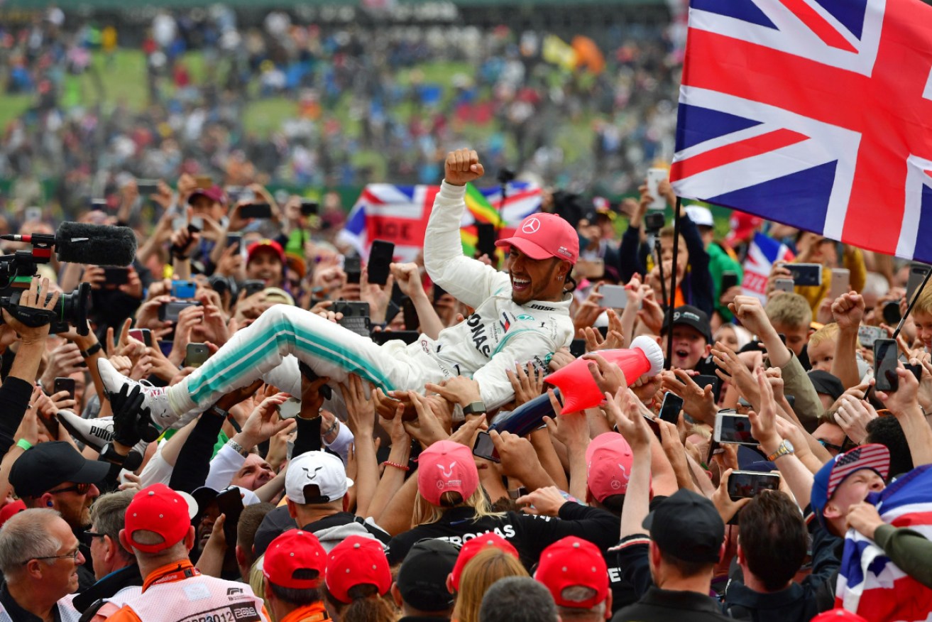 Lewis Hamilton celebrates with fans at Silverstone after the British Grand Prix. 