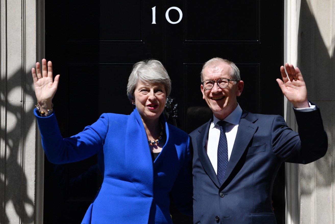 Outgoing Prime Minister Theresa May and husband Philip wave from outside 10 Downing Street on Wednesday. 