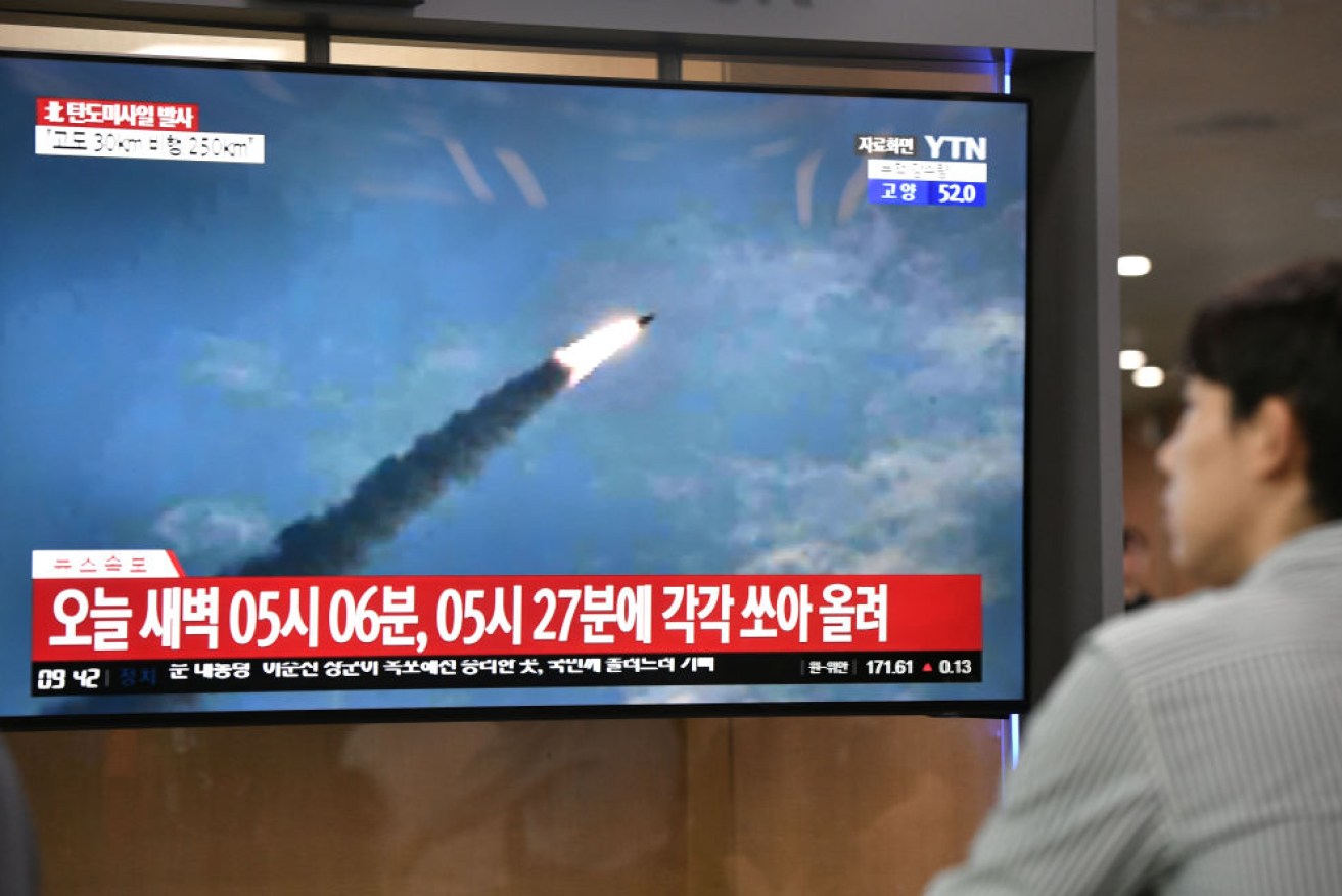 A man watches a television news screen showing file footage of a North Korean missile launch, at a railway station in Seoul.