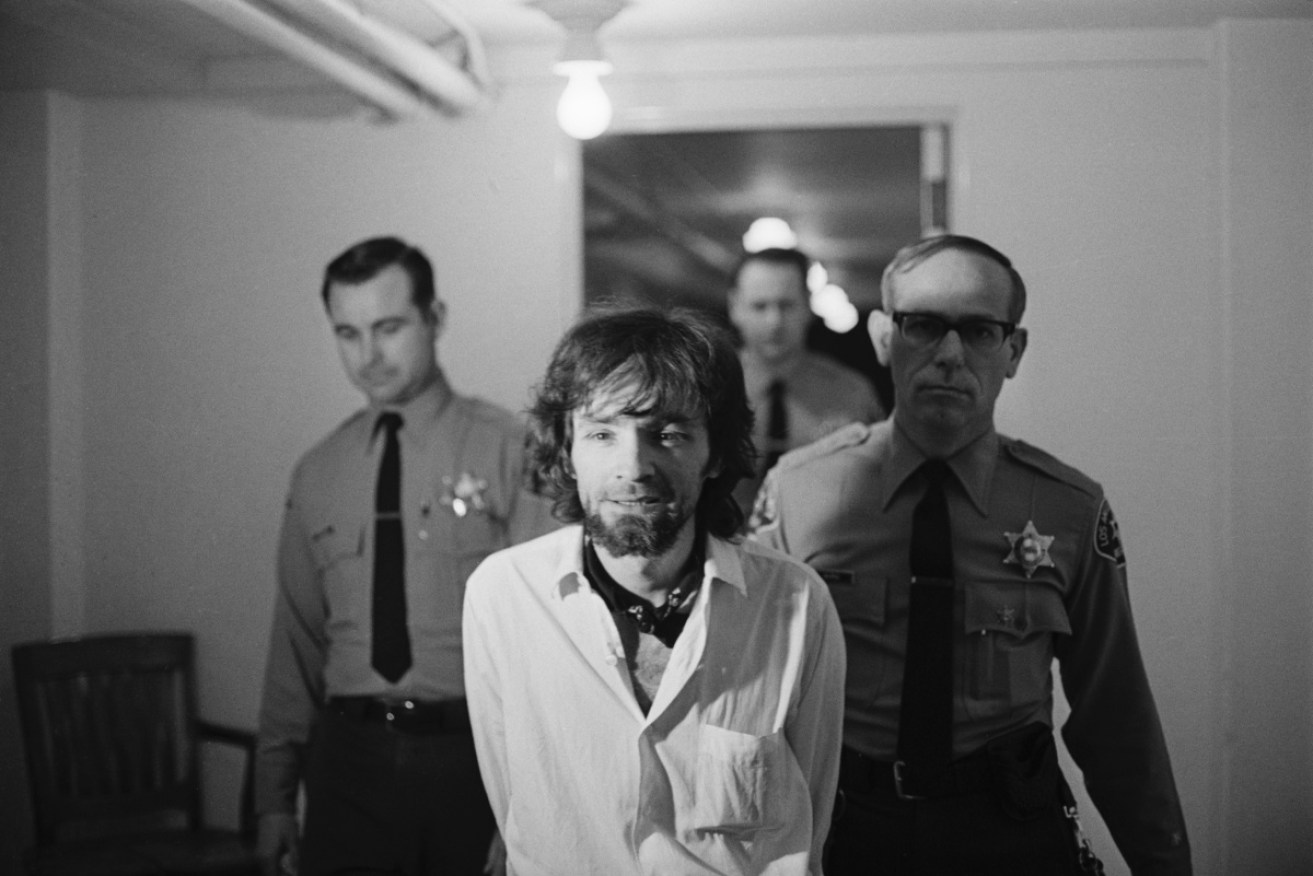 Charles Manson flanked by police at a 1971 court hearing.