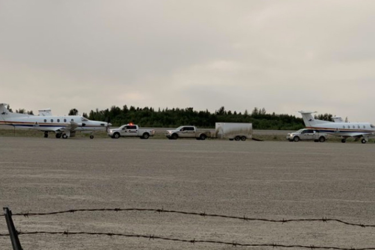 Planes wait to fly the two bodies found on the banks of the Nelson River out to Winnipeg.
