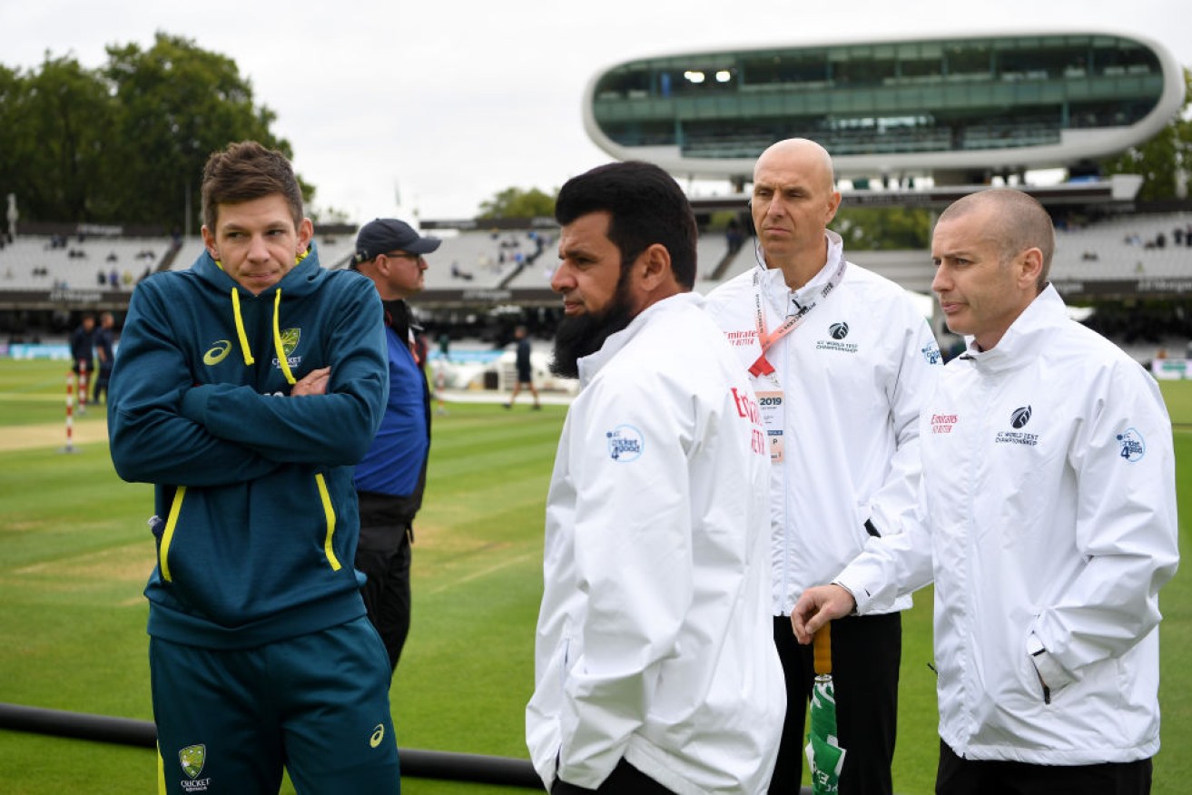 Shivering Australia captain Tim Paine speaks with umpires Aleem Dar and Chris Gaffaney as rain delays the start of day one of the 2nd Ashes Test match at Lord's Cricket Ground. 