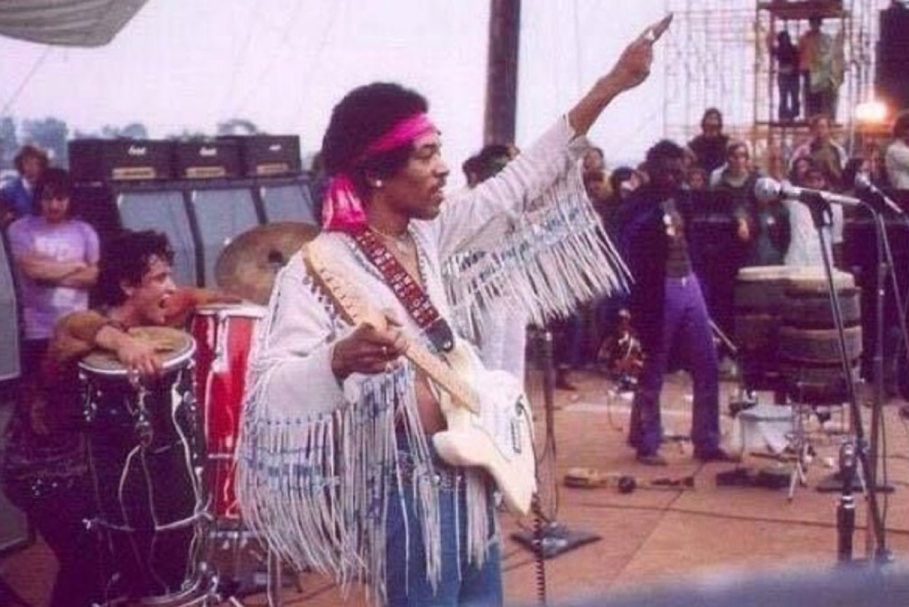 Jimi Hendrix takes the Woodstock stage as the crowd streams out on the last day.