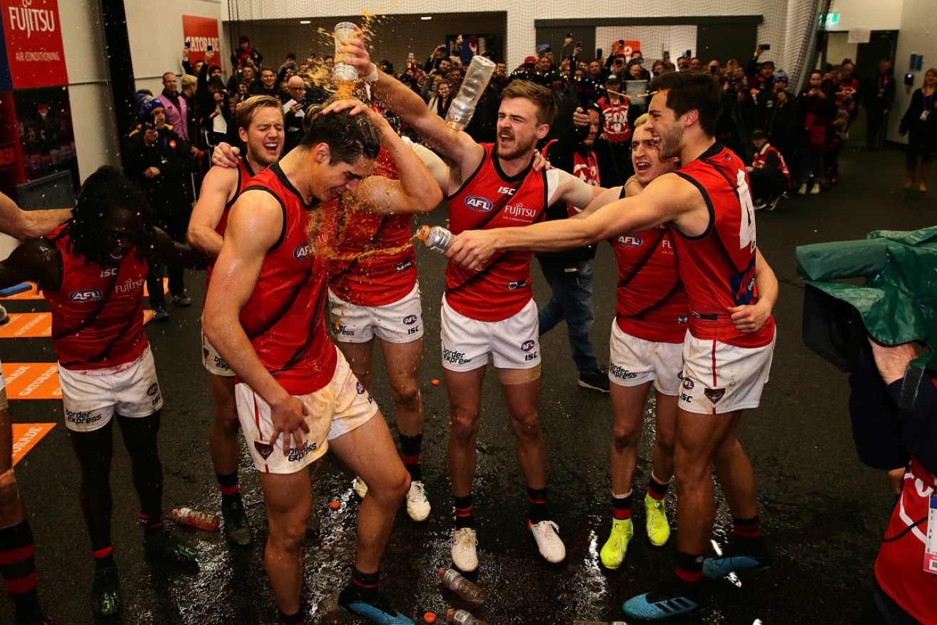 Essendon players celebrate in Perth on Saturday night after their big win. 