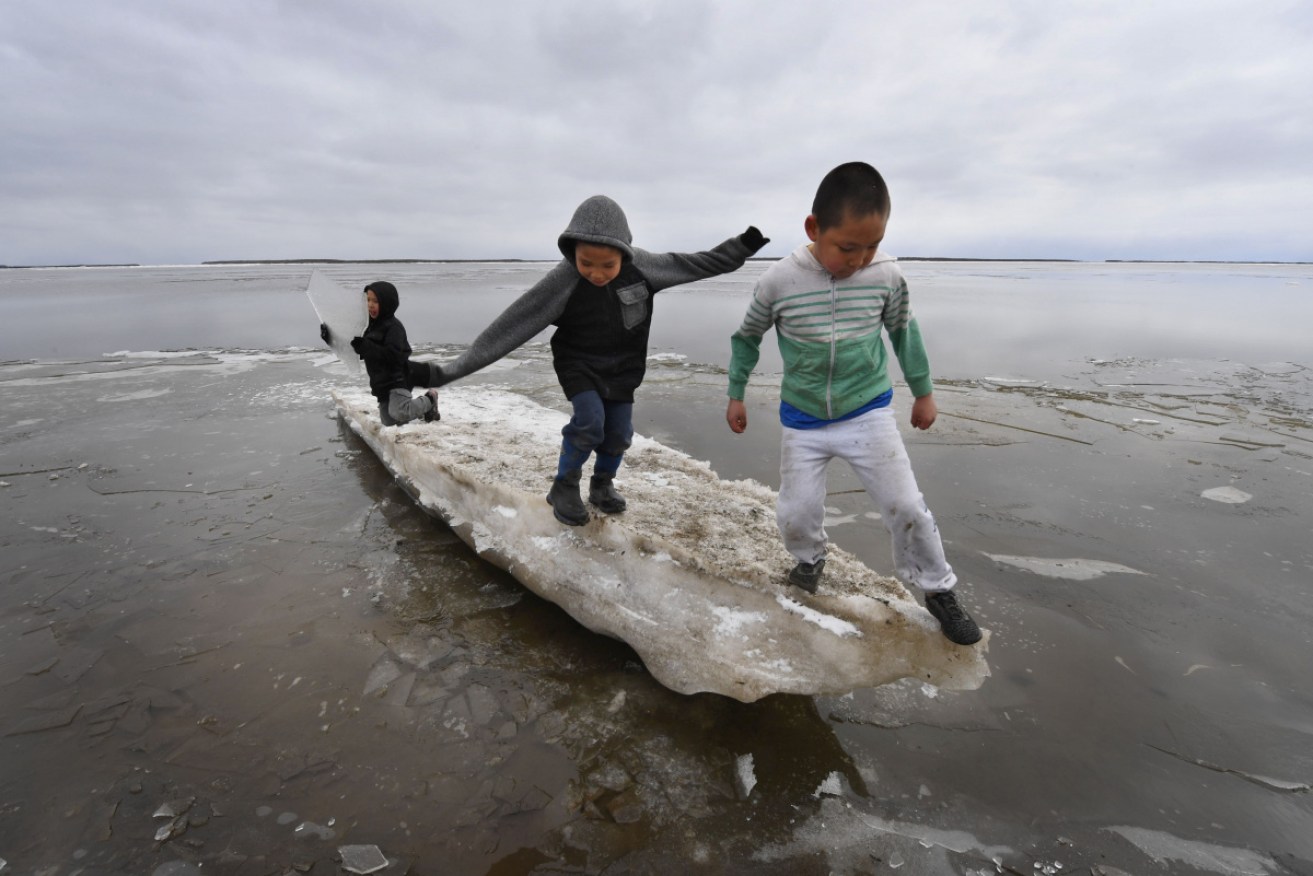School children play on melting ice at climate change-affected villages on the Yukon Delta in Alaska.