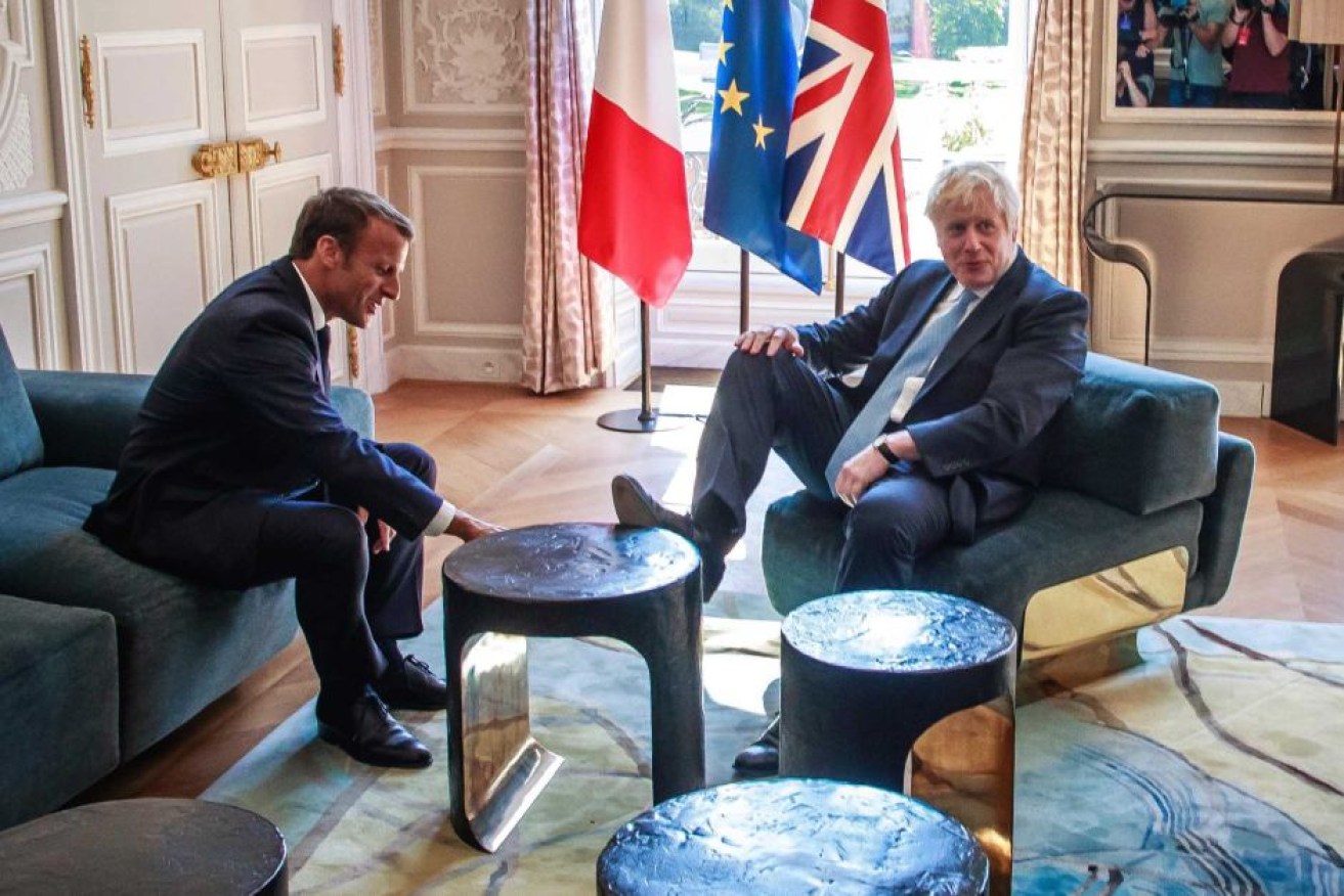 Britain's Prime Minister Boris Johnson gets comfortable with Mr Macron during their meeting at the Elysee Palace.
