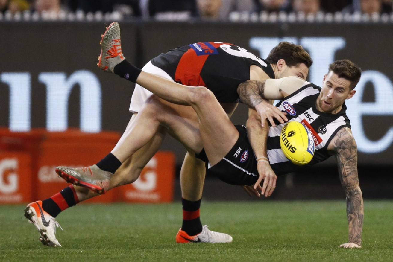 Tough night: Collingwood's Jeremy Howe is tackled by Bomber Patrick Ambrose. 