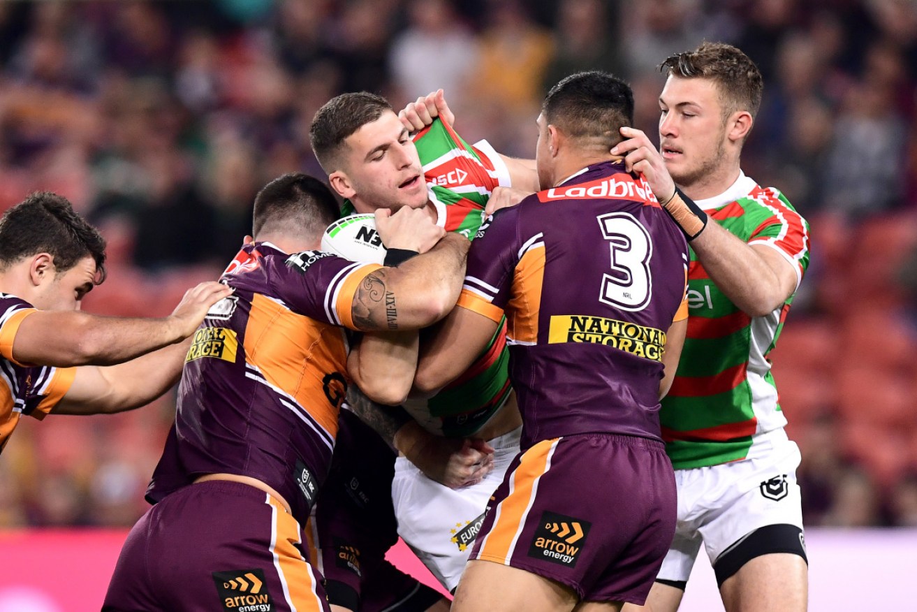 Adam Doueihi of the Rabbitohs is tackled by a team of Broncos. 
