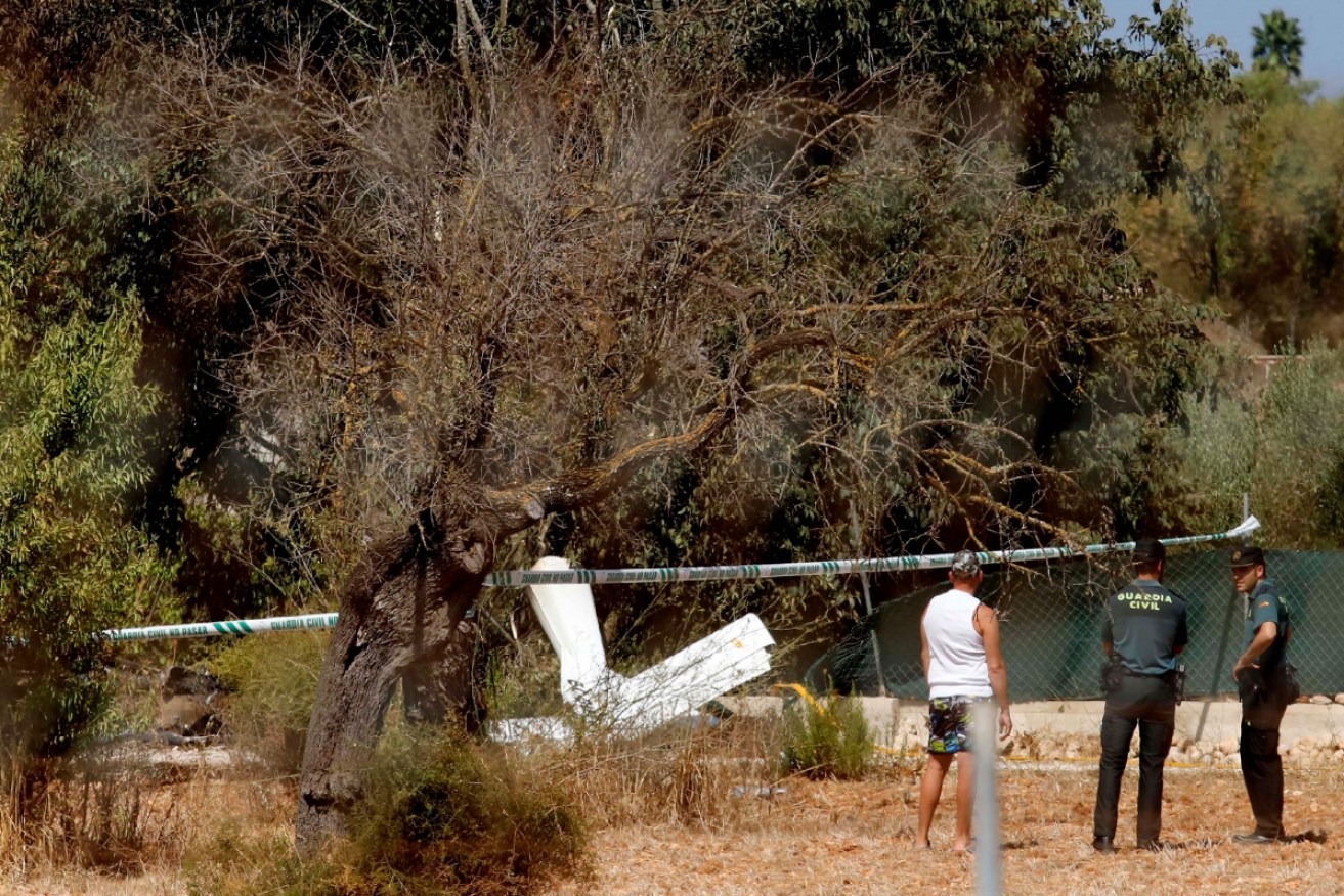 Spanish Guardia Civil guards stand next to the wreckage, after seven people were killed in a mid-air collision between a helicopter and a light aircraft over Mallorca island. 