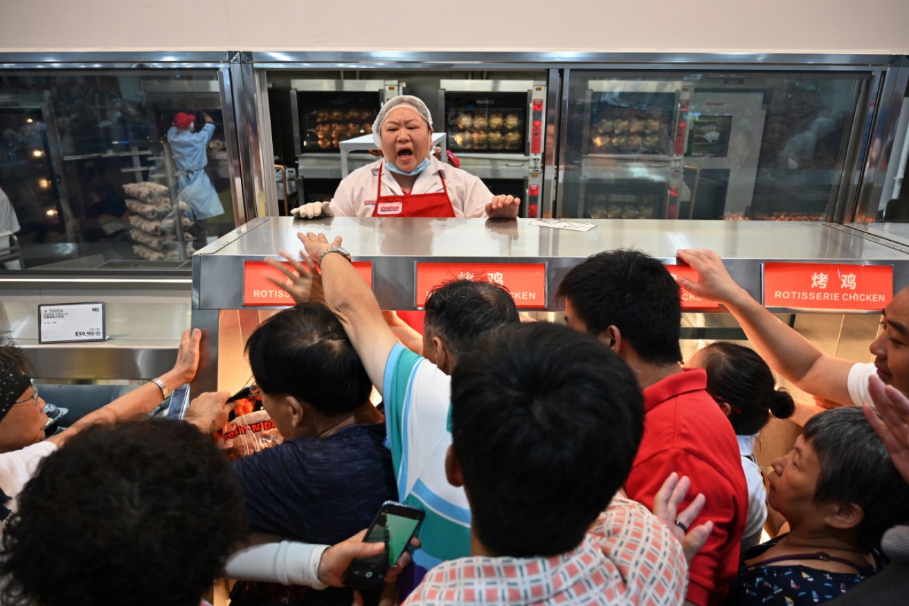 Customers try to get a roast chicken in the frenzied first hours of Costco's new Shanghai outlet.