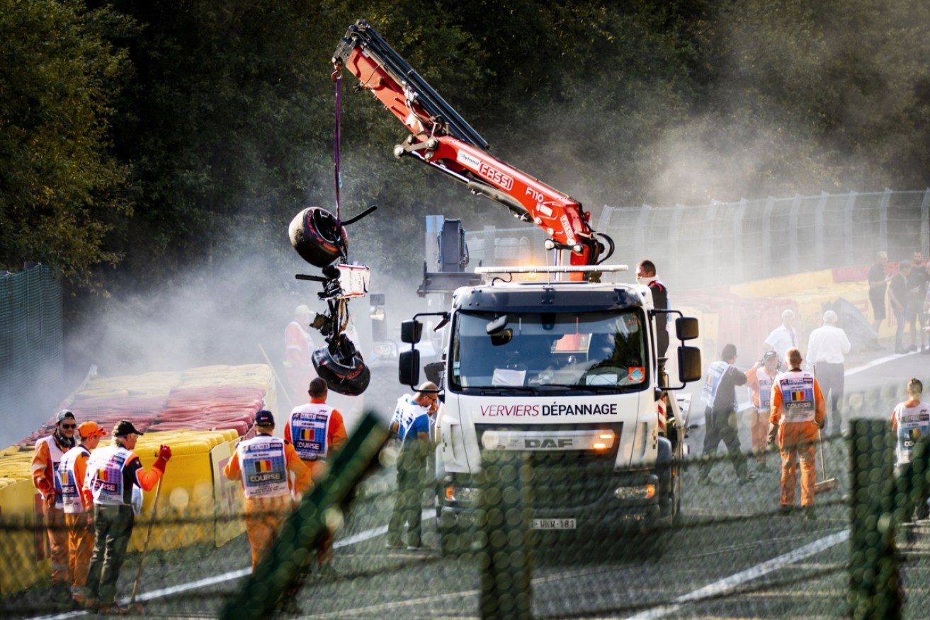 Wreckage of Juan Manuel Correa's car is removed from the Spa track. 