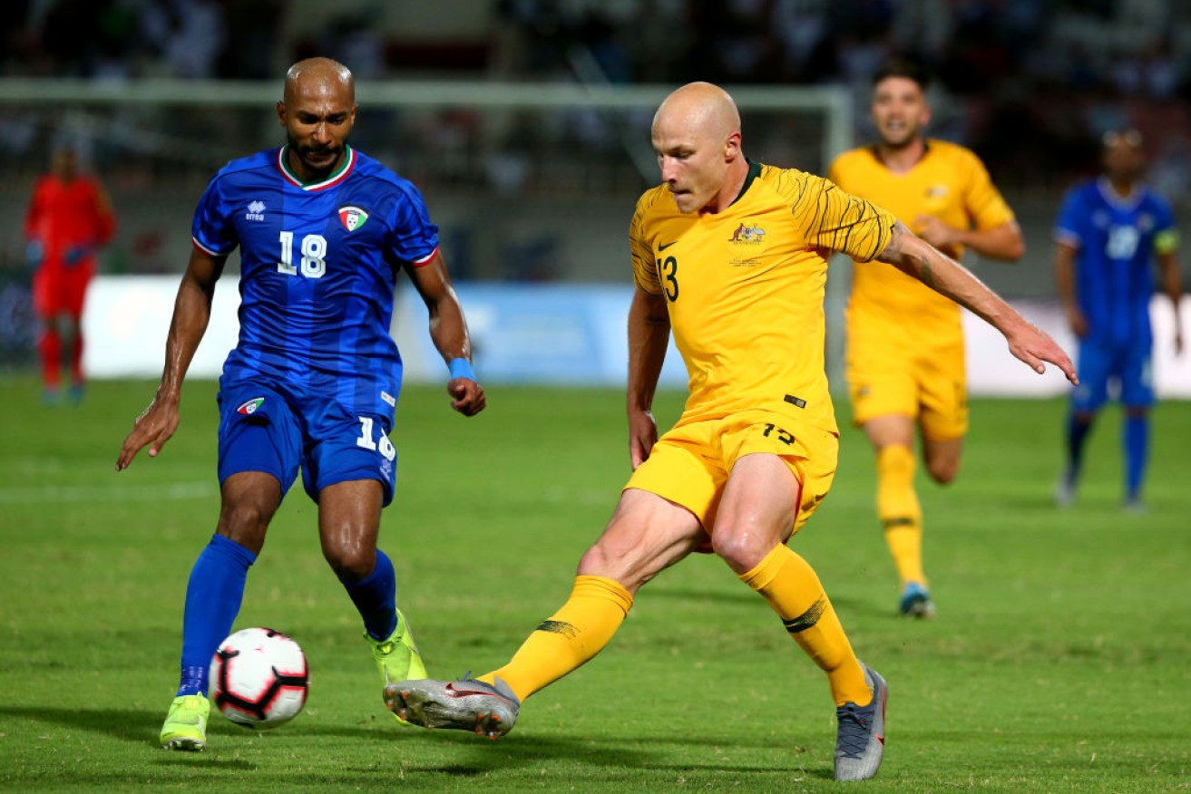 Socceroo Aaron Mooy and Amer Almatoug Alfadhel, of Kuwait, in action in a World Cup qualifying match. 