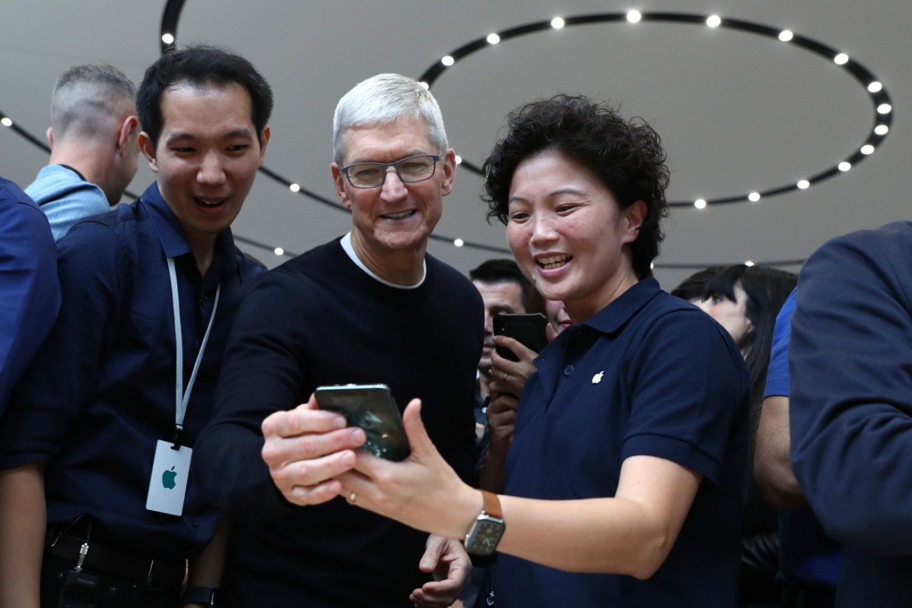 Apple CEO Tim Cook, centre, looks at the new Apple iPhone 11 Pro during a product launch event at Apple's headquarters in Cupertino, California.