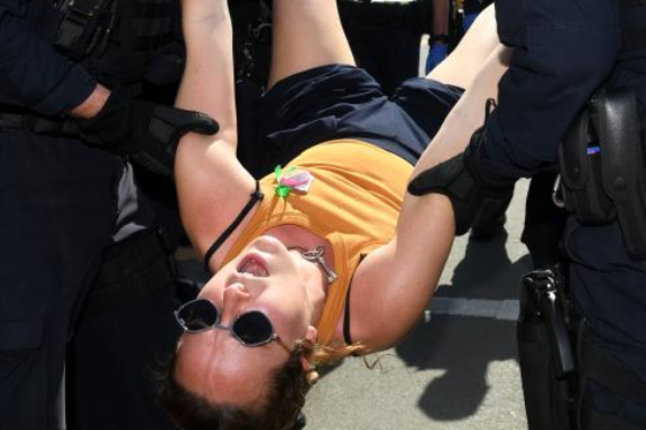 Police haul away a protester at an Extinction Rebellion protest.