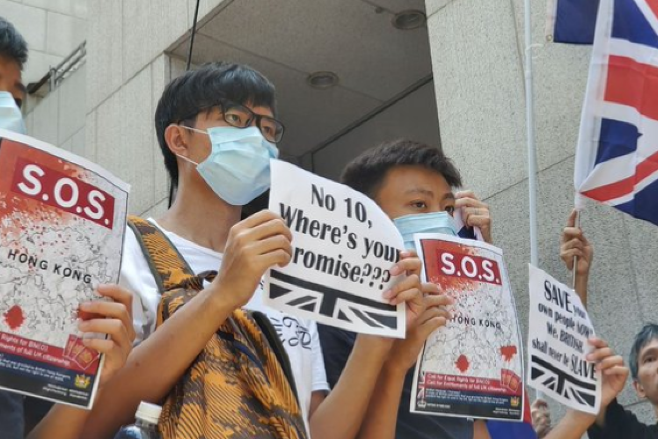 Masked protesters outside the UK's Hong Kong embassy call on Britain to stand with them against China's domination.
