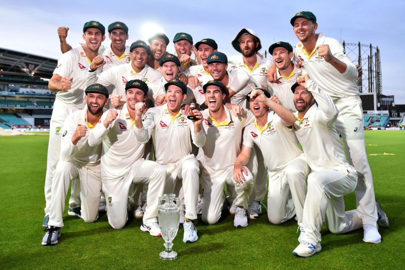 Australia's captain Tim Paine holds the Ashes Urn as the players push aside defeat in the last test to celebrate victory.