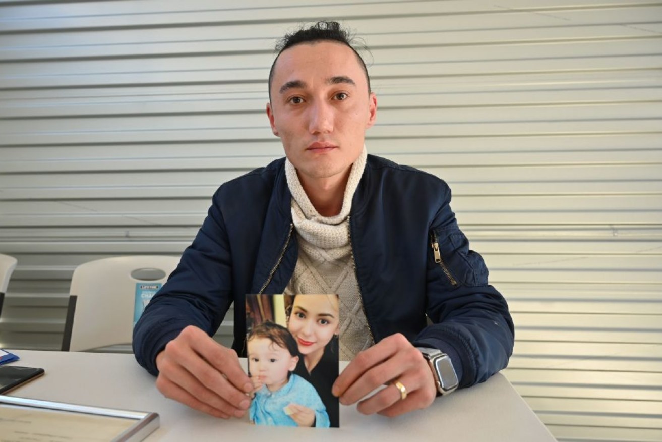 Sydney man Sadam Abdusalam holds up a photo of his Uighur wife Nadila Wumaier and their baby son Lutifeier who remain in China. 