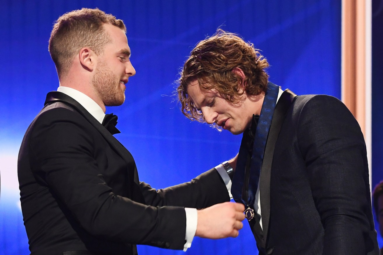 Nat Fyfe (R) receives his Brownlow from last year's winner Tom Mitchell.