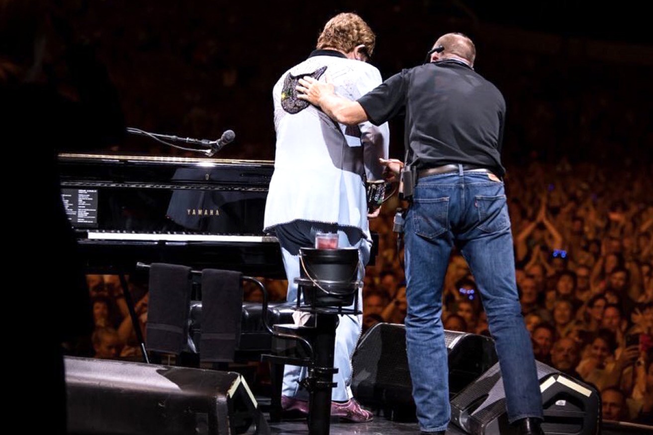 Elton John is helped from stage in Auckland after pneumonia forced him to cut short his show.