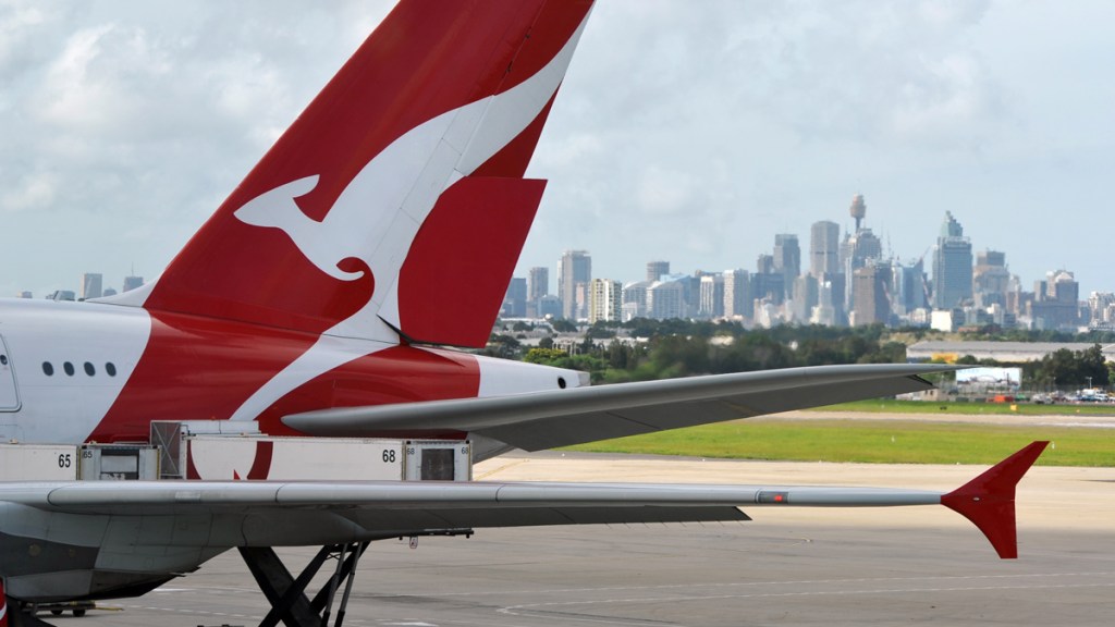 "Sydney, Australia - March, 14th 2012: Quantas aeroplanes and tail fin with the distant view of downtown Sydney - Sydney Airport"