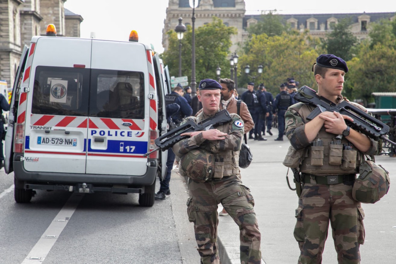 Military personnel block the bridge near Paris Police headquarters after four officers were killed in a knife attack.
