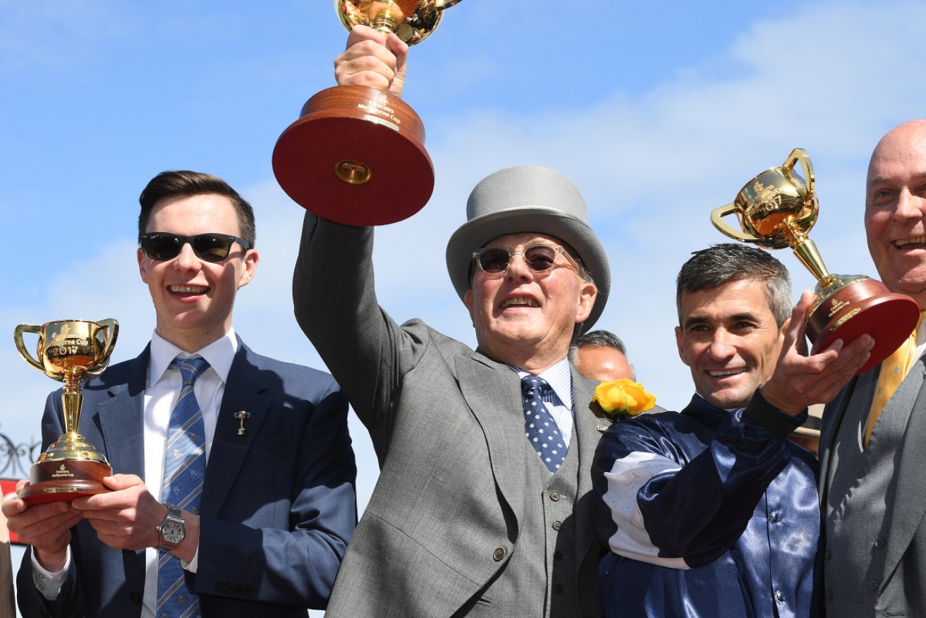 Owner Lloyd Williams (centre) celebrates Rekindling's 2017 Melbourne Cup win with trainer Joseph O'Brien and jockey Corey Brown.