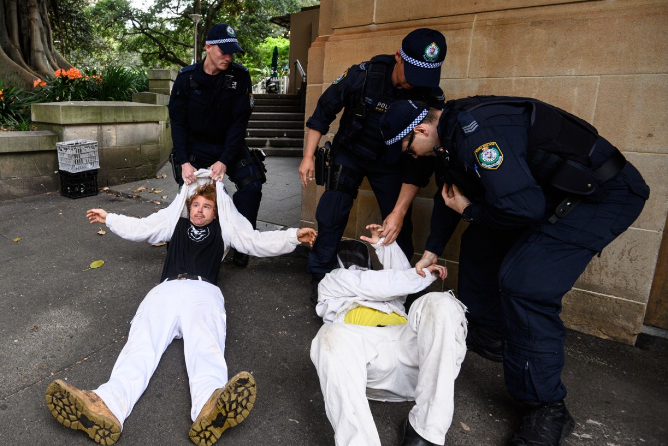 Police remove protesters from the Extinction Rebellion demonstration in Sydney on Tuesday.