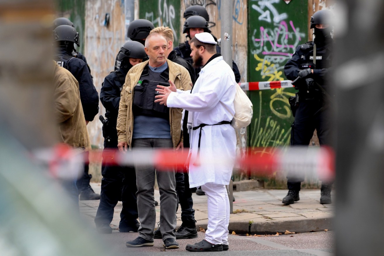 A synagogue visitor talks to police after the shooting in Halle, Germany.