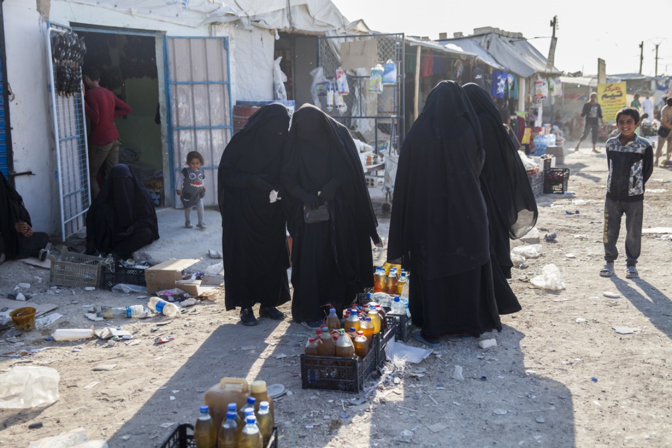 Women buy food at the Al Hawl camp, where about 72,000 people are residing, including 66 Australians.  