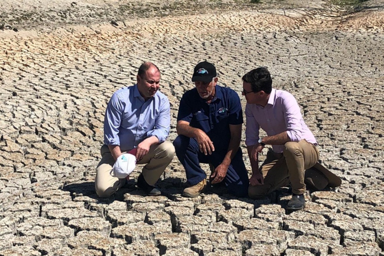 Josh Frydenberg and David Littleproud with a  farmer in July.