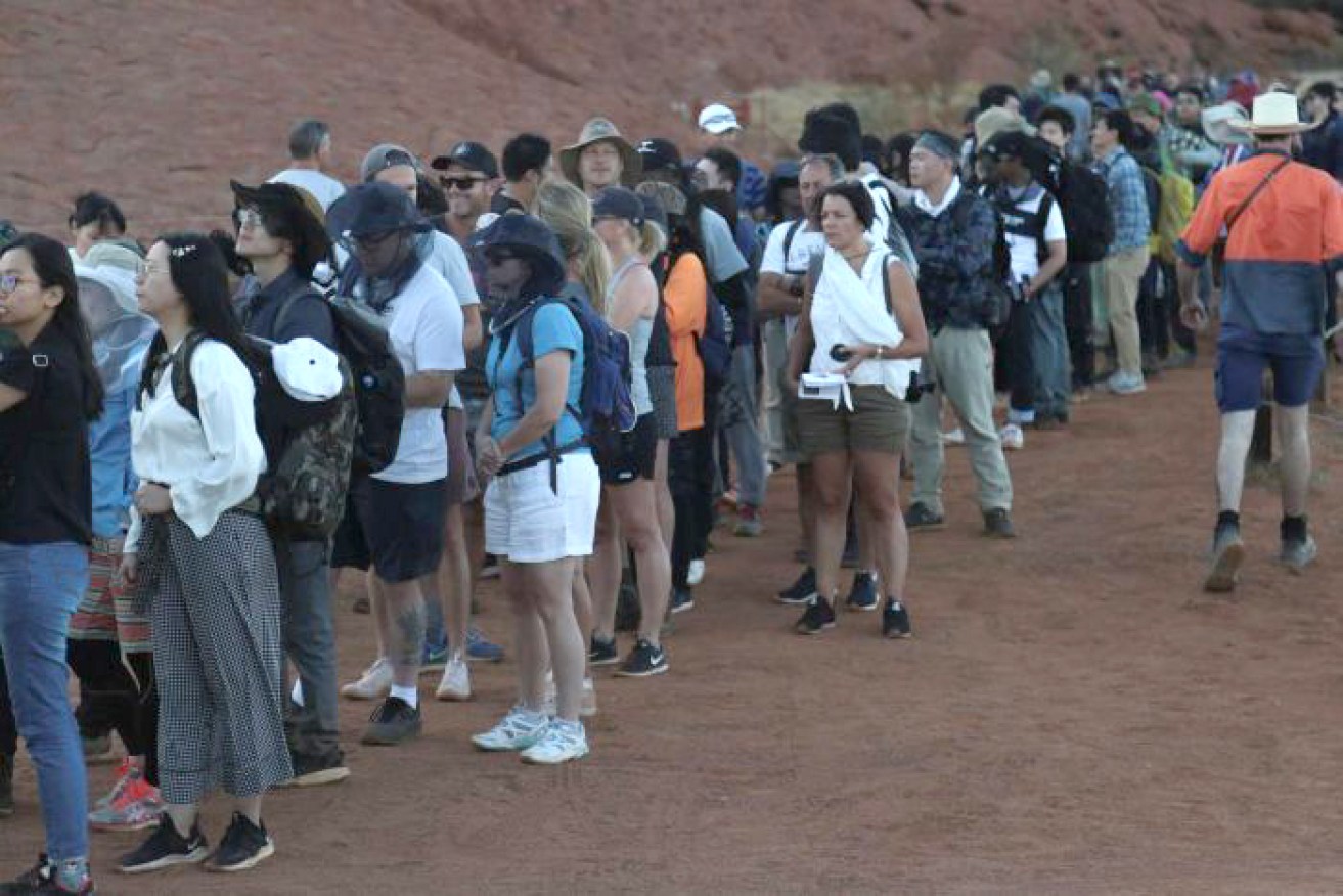 The gathered crowd at the base of Uluru early on Friday morning. <i>Video: ABC</i>