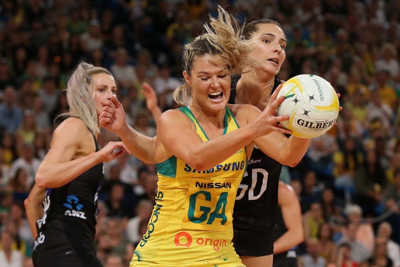 Gretel Tippett of Australia is crunched by Silver Ferns' Karin Burger.